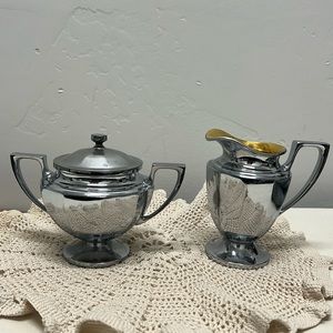 Stainless steel with gold interior creamer and sugar container with lid.